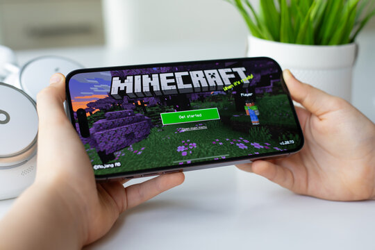 Children hands holding Apple iPhone 15 Pro Max with Minecraft