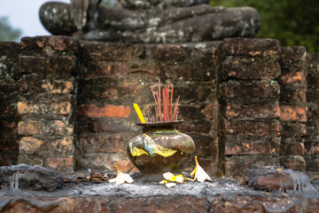Incense in front of a Buddha statue in Sukhothai, Thailand