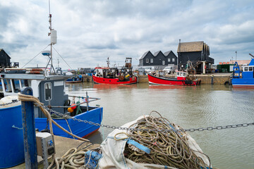 Fishing boats in Whitstable harbour, in Kent, Uk on a spring day.