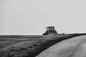 Solitary Tractor Plowing Field - Black and White Photograph