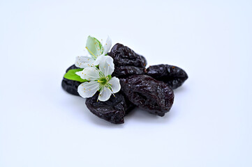 dried prunes and white plum flowers close-up