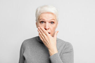 Senior covering mouth in shock or surprise