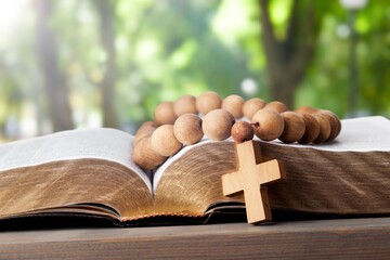 small wooden cross and holy book on table