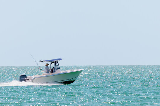 Saltwater fishing boat on a sunny summer day. Fisherman on recreational powerboat cruising the Gulf of Mexico, Florida.