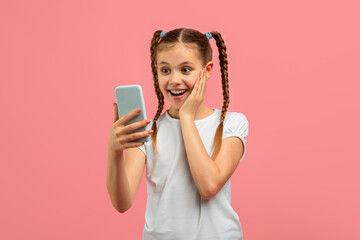Excited girl with smartphone reacting with joy