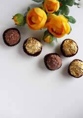 set of chocolates and a bouquet of yellow flowers on a white background