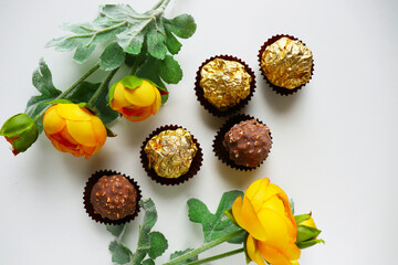 set of chocolates and a bouquet of yellow flowers on a white background