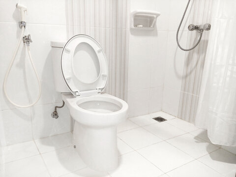 Photograph showcasing a spotless white toilet in a brightly lit restroom, exudes freshness and hygiene, perfect for showcasing modern facilities in commercial spaces, hotels, or residential interiors