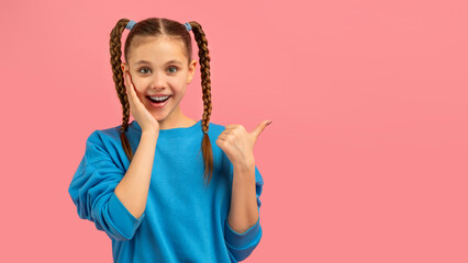 Young girl gesturing with excitement on pink background