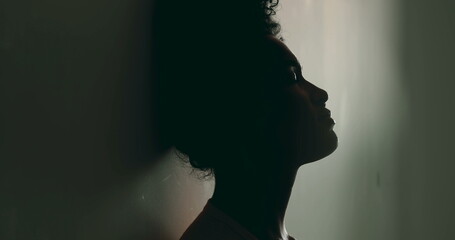 one Young Black Woman in Despair, Leaning Against Wall in Loneliness, Battling Mental Illness, Silhouette of African American in Her 20s Suffering in Solitude