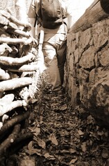 soldier with backpack and military uniform inside the narrow trench during the war in the front line