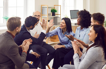 Happy colleagues giving high five at meeting in office, celebrating success, making a deal or...