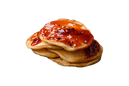 Fresh baked pancakes with delicious jam on a ceramic plate