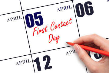 April 5. Hand writing text First Contact Day on calendar date. Save the date.