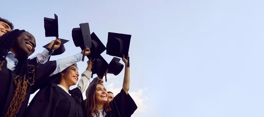 Rucksack Group of happy multiethnic high school, college or university students having fun on graduation day and raising their graduate hats up to clear blue sky. Copy space banner background © Studio Romantic