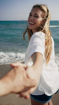 Video of happy beautiful couple enjoying the day while holding each other hand at the beach.