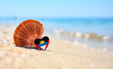 Sandy beach in Antigua and Barbuda. Flag of the Antigua and Barbuda in the shape of a heart and a...