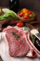 Raw meat and thyme on table, closeup