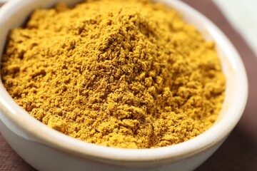 Curry powder in bowl on table, closeup