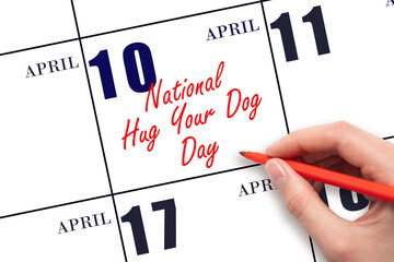 April 10. Hand writing text National Hug Your Dog Day on calendar date. Save the date.