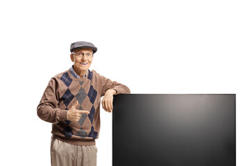 Elderly man leaning on a new flat lcd tv screen and pointing
