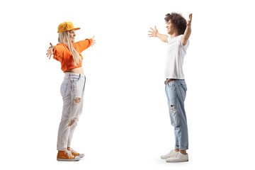 Full length profile shot of a young man and woman standing against each other with arms wide open