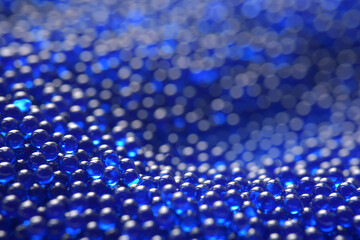 Abstract background in soft selective focus of the blue spherical shape water gel balls, beads or...