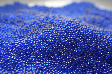 Abstract background in soft selective focus of the blue spherical shape water gel balls, beads or...