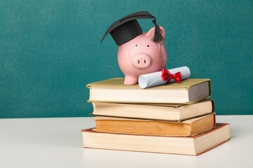 Graduation hat on piggy bank with set of books