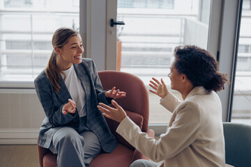 Smiling diverse businesswomen is distracted from work and talking in office during break