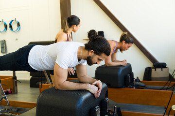 Pilates class in action on reformer beds - 792034417