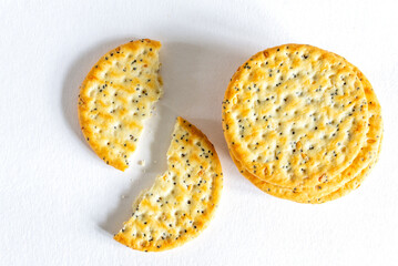 Sesame and poppy seed crackers  on white background. One broken biscuit. Close-up, top view.