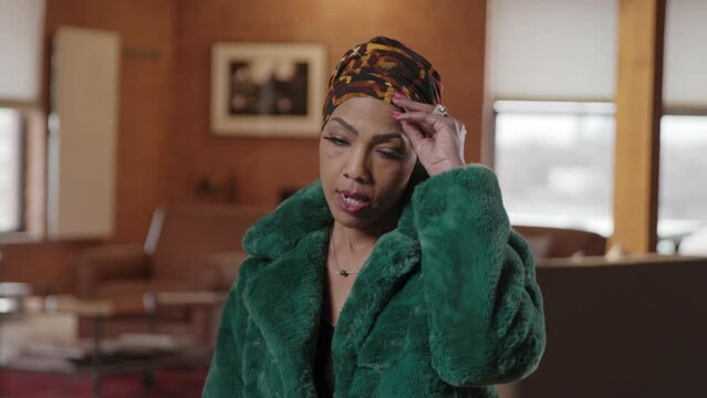 Woman with alopecia takes off her cap during an interview