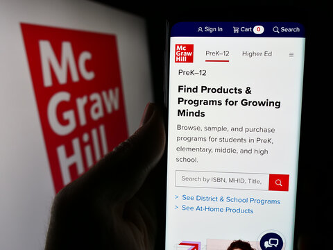 Stuttgart, Germany - 04-12-2024: Person holding cellphone with webpage of US publishing company McGraw Hill LLC in front of business logo. Focus on center of phone display.