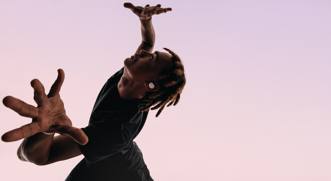 Energetic gen z dancer moves to wireless music in studio