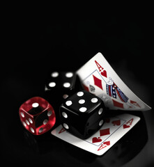 Obraz premium Elegant casino objects on a black surface - A classy, realistic image of playing cards and dice, implying themes of gambling and entertainment