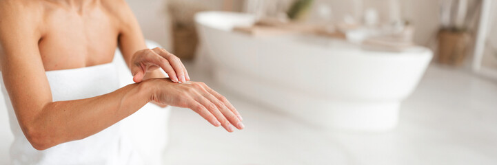 Unrecognizable middle aged woman applying hand cream, making beauty treatments