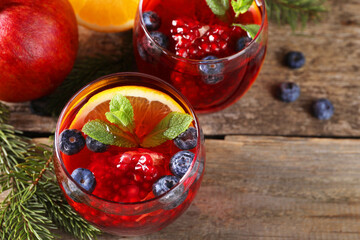 Aromatic Christmas Sangria drink in glasses on wooden table, above view