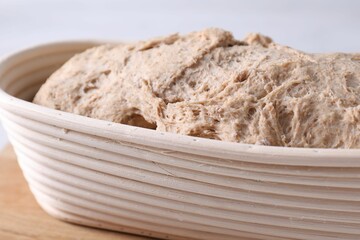 Fresh sourdough in proofing basket on table, closeup