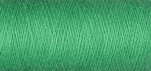 macro texture of a skein of green sewing thread