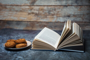 Open book next to a plate of cookies