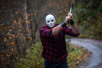 Handsome Strong Creepy Man with Axe Hides Behind a Mask