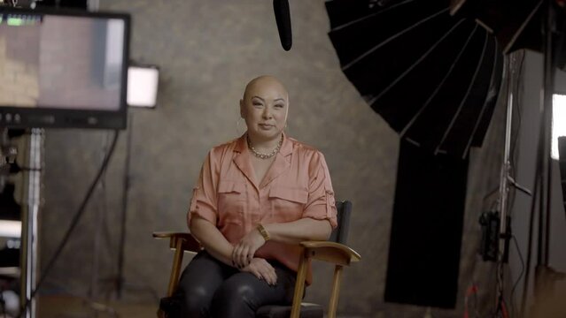Woman with alopecia universalis sits on a film set before an interview