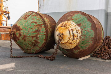 two rusty boilers used on a heck trawler connected with rusty steel chain