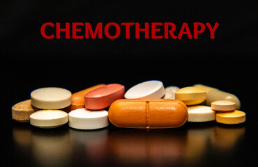 A pile of medication pills on a black background with the inscription Chemotherapy. Medicines for Chemotherapy