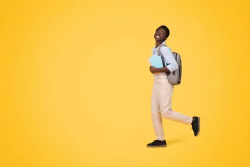 Foto op Canvas African american woman walking with books isolated © Prostock-studio