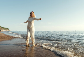 Woman Standing on Beach by Ocean
