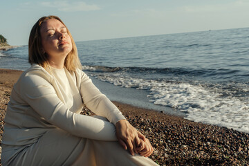Woman Sitting on Beach by Ocean