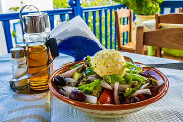 Plate of Greek salad served with traditional goat feta cheese on taverna table in Kastro village,...