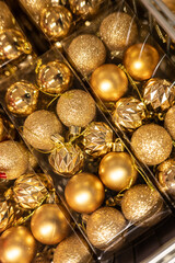 Golden Christmas ornaments in plastic packaging.